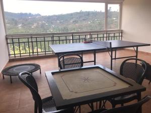 a room with two tables and chairs and a balcony at Cherry Blossom Homestay in Kodaikānāl