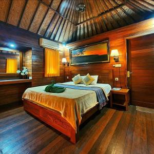 a bedroom with a bed in a wooden room at Lembongan Tropical Guesthouse in Nusa Lembongan