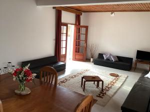 a living room with a table and a couch at Hai Villa Andoharanofotsy Antananarivo in Antananarivo +19 photos