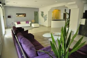 uma sala de estar com um sofá roxo e uma mesa em Hotel Lugano em Riccione