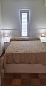 a bedroom with a large bed with two tables and a window at MACH HOUSE you will like it ! in Tamariu