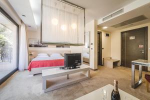 a bedroom with a bed and a tv on a table at Hotel & Apartments HEC Residence in Sveti Stefan