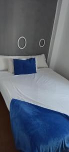 a bedroom with a bed with blue sheets and pillows at Santa Justa in Seville