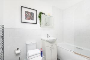 a white bathroom with a sink and a toilet at 3beds Mews House in Oxford Circus in London +26 photos