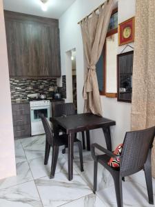 a dining room with a black table and chairs at La Casa de Amelia in Puerto Baquerizo Moreno