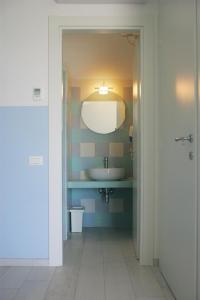 La salle de bains est pourvue d'un lavabo et d'un miroir. dans l'établissement Residence Le Ali del Conero, à Marcelli