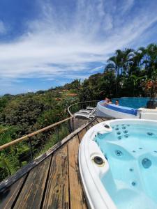 a bath tub sitting on top of a wooden deck at Villa Roca Boutique Resort & Suites - ADULT ONLY in Manuel Antonio