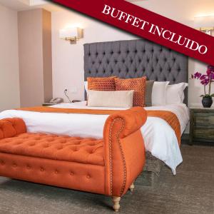 a large bed with an orange couch in a room at Hotel Ticuán in Tijuana