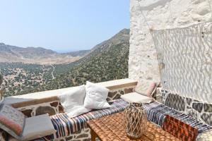 a balcony with a table and chairs with a view at Volcano View Nisyros in Emporeiós
