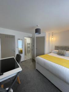 a bedroom with a bed and a desk and a tv at The Villas holiday homes in Horden