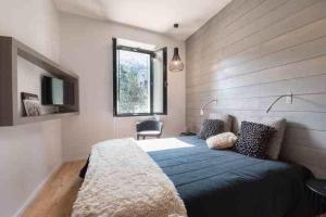 a bedroom with a blue bed and a window at Maison du cap **** in Saint-Lary-Soulan