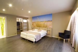 ein Schlafzimmer mit einem Bett und einem Gemälde einer Wüste in der Unterkunft Hotel Bero in Ostende + 53 Fotos