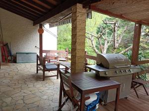 a grill on a patio with a table and chairs at Les Eaux Tranquilles in Belvianes-et-Cavirac