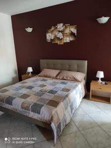 a bedroom with a bed with two tables and two lamps at La Gioia di Casa in Àrbatax