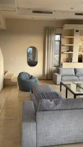 a living room with two couches and a table at La Villa Toscana: Pool & Elah Valley vineyard view in Adderet