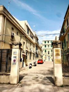 an empty street with a red car driving down a street at Appartamento nel cuore di Messina in Messina