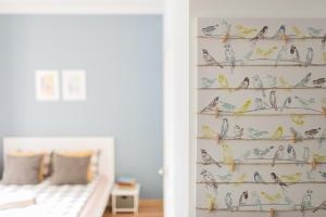 een woonkamer met een muur met vogels en vlinders bij Light Studio Apartment in Liepāja