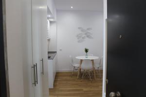 a small kitchen and dining room with a table and chairs at Encanto de la Catedral Ha Loft in Cádiz