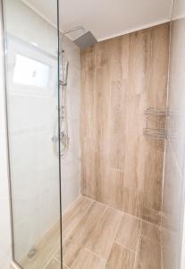 La salle de bains est pourvue d'une douche avec une porte en verre. dans l'établissement Elounda Dream House 2, à Elounda