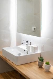 La salle de bains est pourvue d'un lavabo blanc et d'un miroir. dans l'établissement Elounda Dream House 2, à Elounda