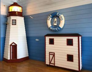 a toy house and a lighthouse in a room at Sea Echo Motel in Port au Choix