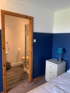 a bedroom with a bed and a bathroom with a toilet at Orchard House Lodges by Ecohuman in Haddington