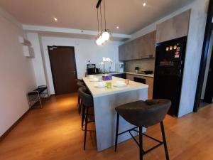uma cozinha com um balcão branco e um frigorífico preto em Best Moments suite 1 em Kuantan