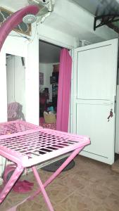 a pink bunk bed in a room with a door at SUPER CHAMBRE ÉQUIPÉE chez l habitant in Le Gosier