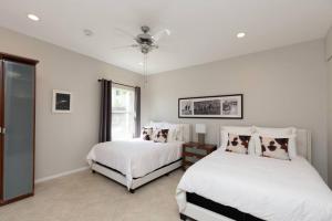 a bedroom with two beds and a ceiling fan at North Park Studio Bungalow in San Diego