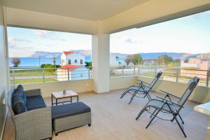 a living room with a couch and chairs on a balcony at Ammos Apartment - brand new, stylish, by the beach in Kissamos