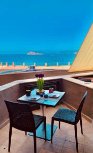 un tavolo e sedie su un balcone con vista sull'oceano di Una finestra sul Blu a Teulada