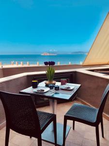 un tavolo e sedie su un balcone con vista sull'oceano di Una finestra sul Blu a Teulada
