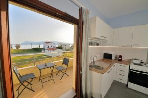 a kitchen with a balcony with a table and chairs at Ammos Apartment - brand new, stylish, by the beach in Kissamos