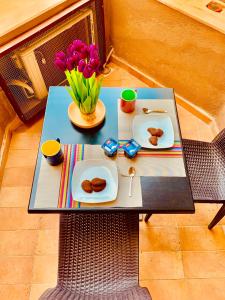 un tavolo con piatti di cibo e un vaso di fiori di Una finestra sul Blu a Teulada