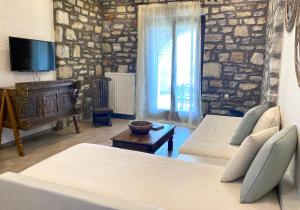 a living room with two beds and a television at Casa Kaly in Agia Anna Naxos