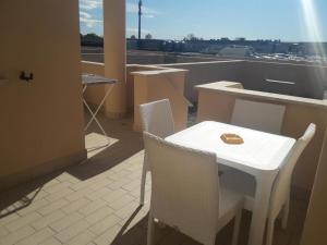 - Balcón con mesa blanca y sillas en Monnalisa Village, en Fiumicino
