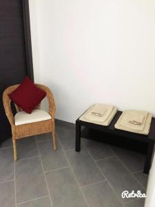 a living room with a table and a chair with a red pillow at Monnalisa Village in Fiumicino