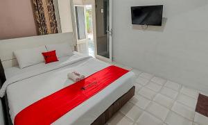 Un dormitorio con una cama con una manta roja. en RedDoorz near Alun Alun Batu 2, en Batu