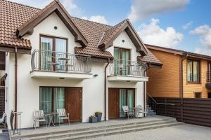 una casa con balcón y mesas y sillas en Palanga Deluxe, en Palanga
