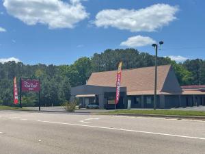 a building on the side of a road with a dealership at Red Roof Inn LaGrange in LaGrange