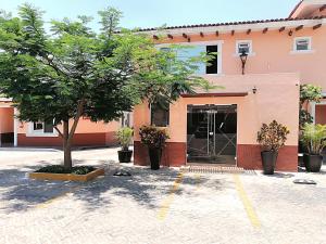 a building with a tree in front of it at Hotel Aquiles in Guadalajara