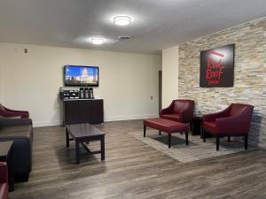 a waiting room with red chairs and a tv at Red Roof Inn LaGrange in La Grange