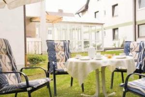 einen Tisch und Stühle auf einer Terrasse mit Tisch und Stühlen in der Unterkunft Kurhotel Kaiser in Bad Wörishofen