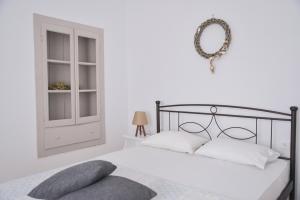 a white bedroom with a bed and a wreath on the wall at Diamanto's guest house in Tripiti