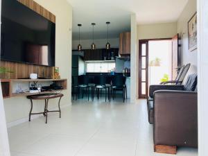 a living room and kitchen with a couch and a table at Casa Lofstrom uma luxuosa com linda vista! in Tibau