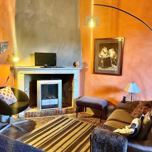 a living room with a couch and a fireplace at Villa I Bossi in Arezzo