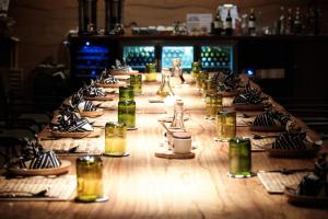 a long wooden table with plates and glasses on it at UMVA Muhazi in Muhazi