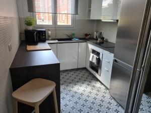 a kitchen with white cabinets and a black counter top at Paris visit in La Garenne-Colombes