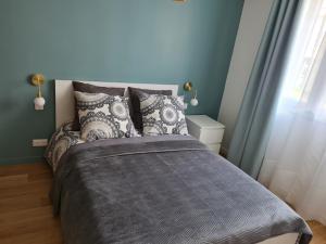 a bedroom with a bed with a gray blanket at Paris visit in La Garenne-Colombes