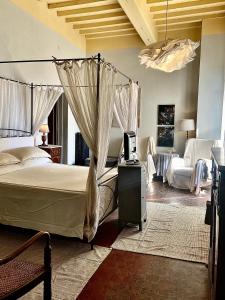 a bedroom with a canopy bed and a living room at Villa I Bossi in Arezzo